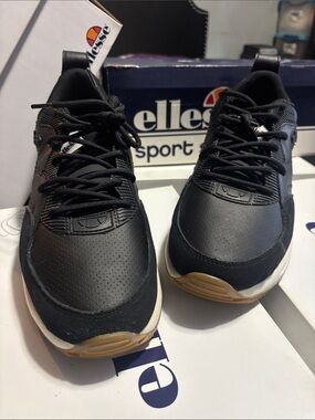 Ellesse Black Sneakers with White Midsole and Red Heel Accent.